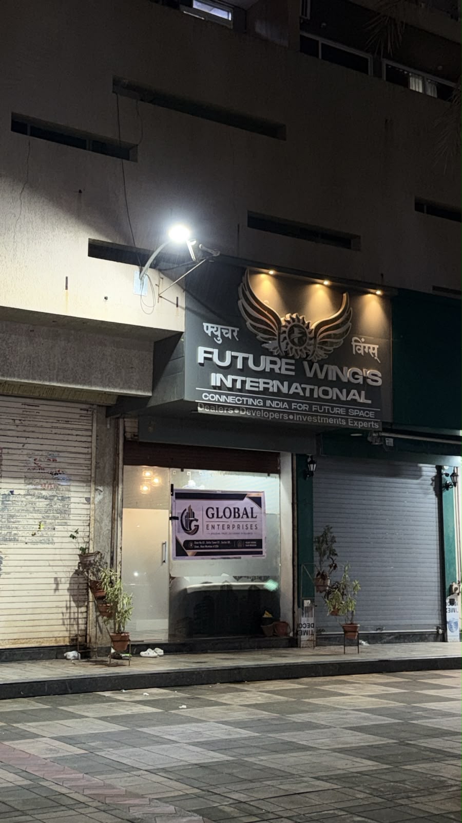 Night photo of Future Wings International storefront with Global Enterprises sign on the door