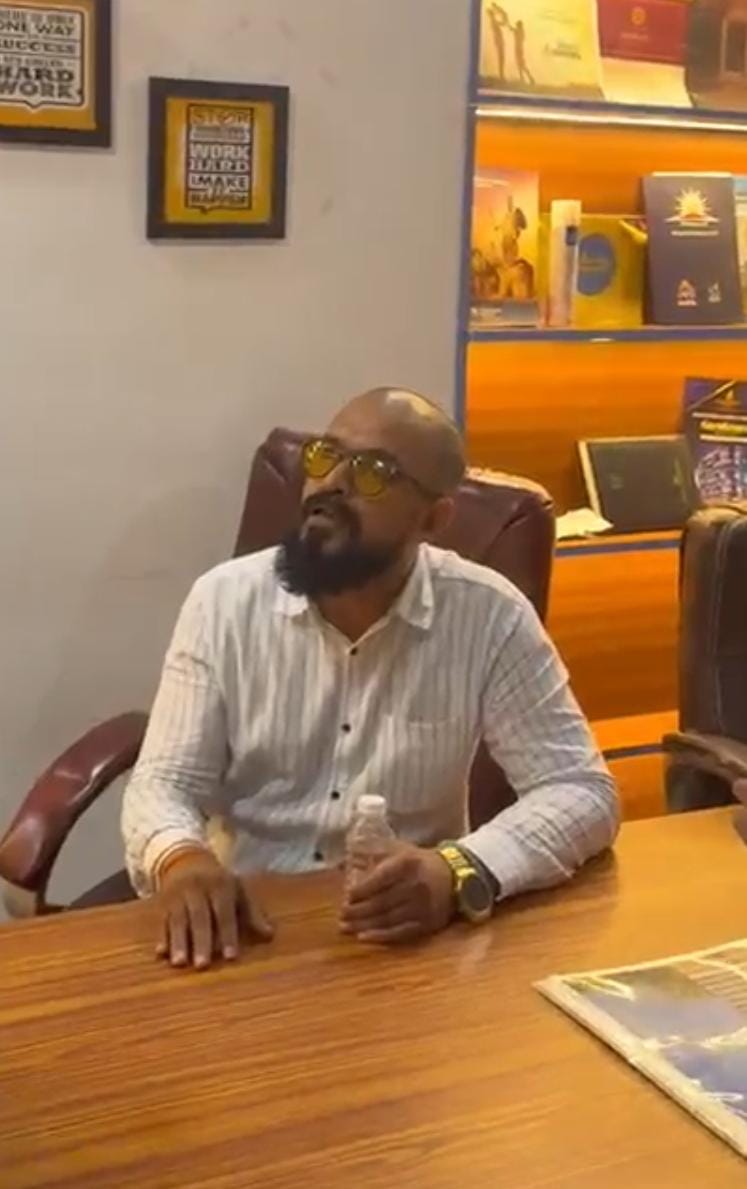 Man customers identify as Sumit Sudhir Choudhari at a desk in an office